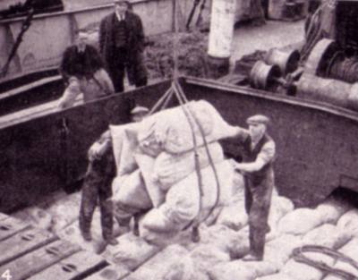 Photo of men working a ships hatch in the 1930s