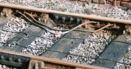 Close up photo showing electrical bonding for track circuits and electric traction power return